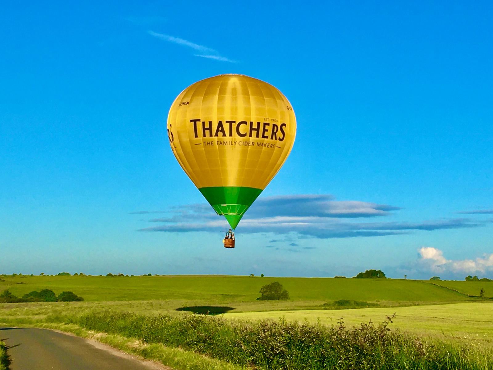 A First Flight balloon over green Somerset fields